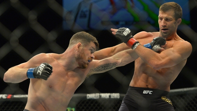 Michael Bisping (blue gloves) and Luke Rockhold (red gloves) during their middleweight championship bout at UFC 199 Saturday.