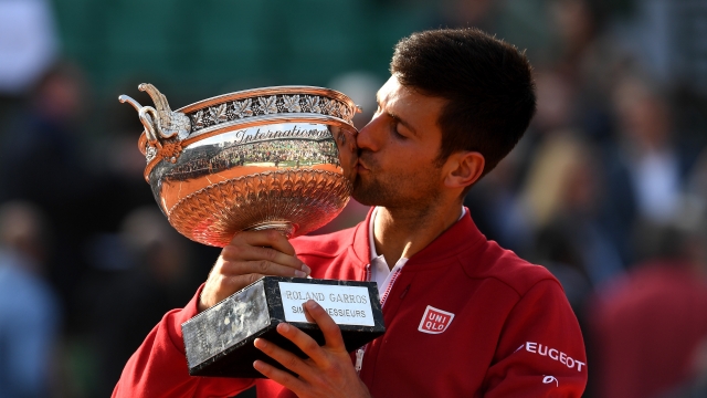 Novak Djokovic kisses the trophy following his victory at the 2016 French Open