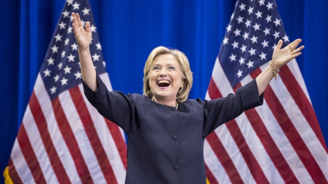 Hillary Clinton raises her arms at a campaign rally