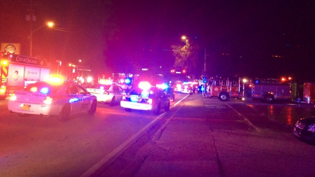 Police cars and fire trucks with lights flashing at night near Pulse Orlando Night Club.
