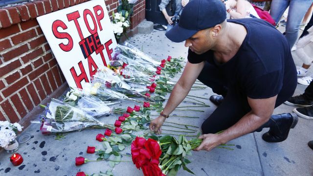 Man puts down roses at vigil outside the Stonewall Inn