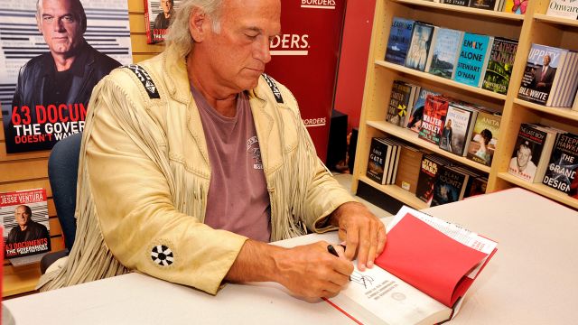 Former Minnesota Gov. Jesse Ventura signs one of his books.