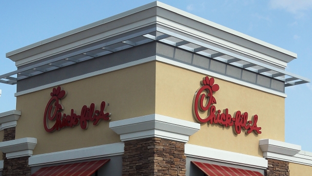 The outside of a Chick-fil-A restaurant with its red logo sign.