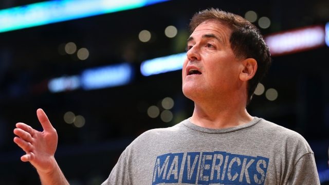Dallas Mavericks owner Mark Cuban talks to a referee during a timeout in the game