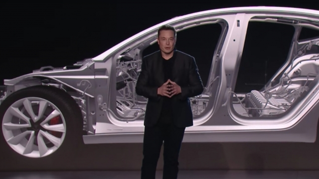 Elon Musk presents one of Tesla's electric vehicles.