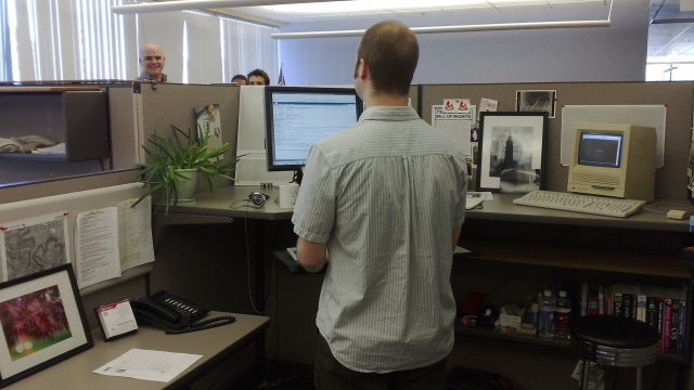 A man working at a standing desk.