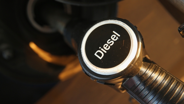 The diesel fuel nozzle of a pump deposits fuel into a Volkswagen car.