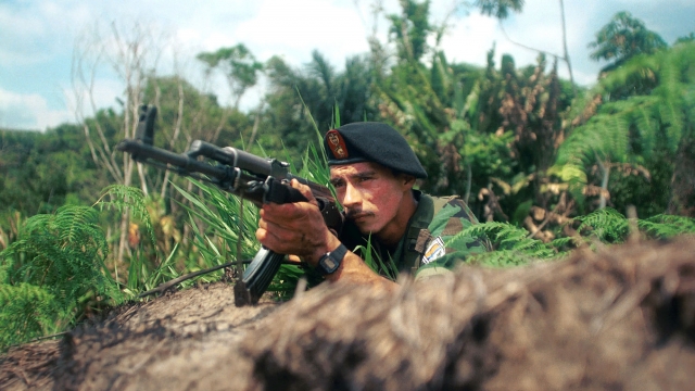 A FARC guerrilla guards a road in Colombia.