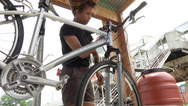 Bronzeville Bike Box Manager Samantha Scipio working on a bike repair.