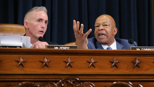 Rep. Trey Gowdy sits on the left, and Rep. Elijah Cummings sits on the right with his one hand up during a heated hearing.