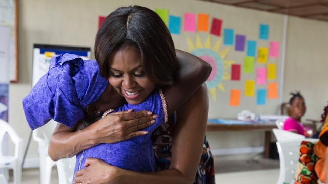 Michelle Obama hugs a young girl.