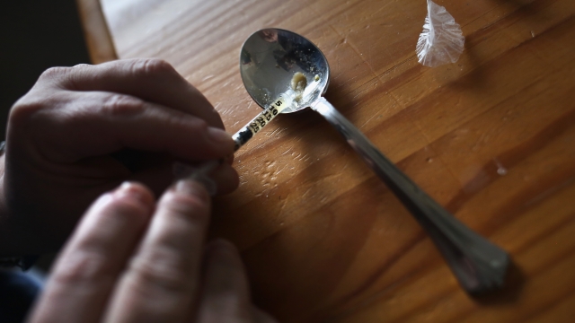 Hands holding a needle getting heroin from a spoon March 23, 2016 in New London, CT.