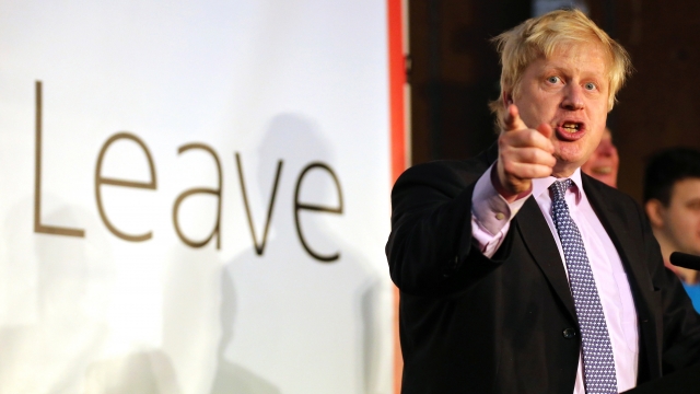 Boris Johnson points next to a "Leave" sign while campaigning to leave the EU