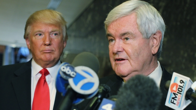Republican presidential candidate and former Speaker of the House Newt Gingrich speaks to the media as Donald Trump listens.