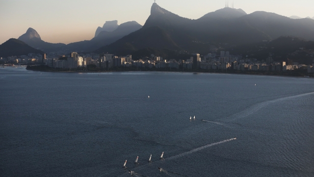 Sailboats sail in the polluted Guanabara Bay, site of the Olympic sailing events, on July 4, 2016 in Rio de Janeiro.