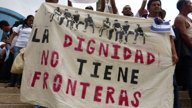 Migrants in Mexico City hold a sign that reads, "Dignity has no borders."