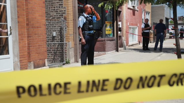 Police investigate a crime scene after two people were shot June 15, 2016 in Chicago.