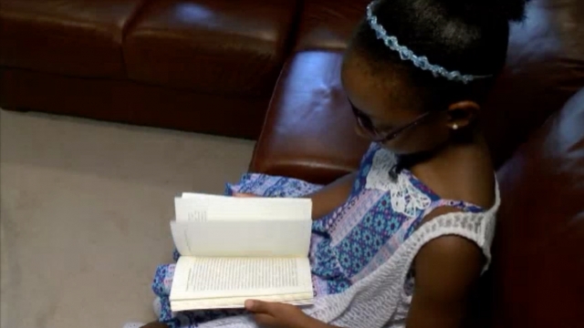 Eight-year-old author Layah Vasser holds her book.