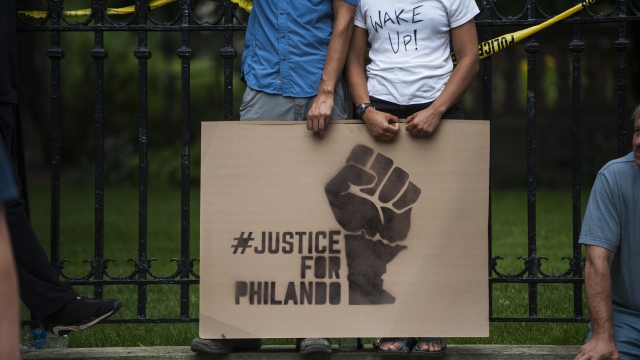 A couple hold a sign protesting the killing of Philando Castile.