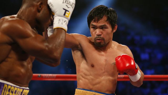 Manny Pacquiao (R) throws a right at Timothy Bradley Jr. during their welterweight championship fight.