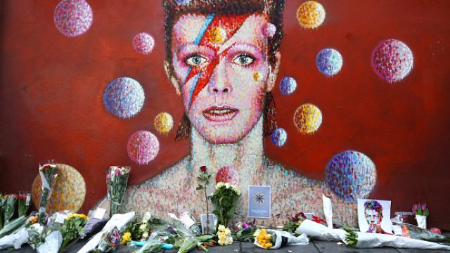 Flowers are laid beneath a mural of David Bowie in Brixton on January 11, 2016, in London, England.