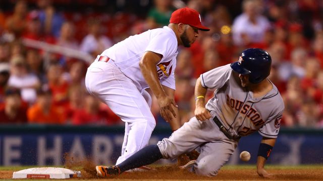 Jose Altuve #27 of the Houston Astros slides safely into throw base against Jhonny Peralta #27 of the St. Louis Cardinals.