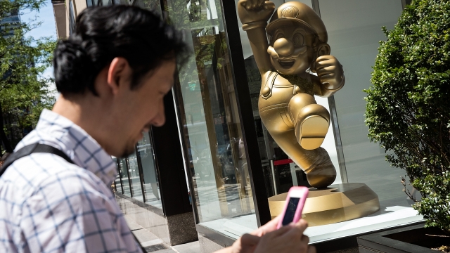 A man plays "Pokémon Go" on his smartphone outside Nintendo's flagship store, July 11, 2016 in New York City.