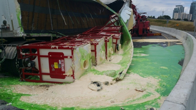 A pool of green- and cream-colored condiments next to an overturned truck.