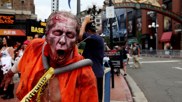 A zombie character greets people along 5th Avenue in the Gaslamp Quarter at Comic Con on July 19, 2013 in San Diego.