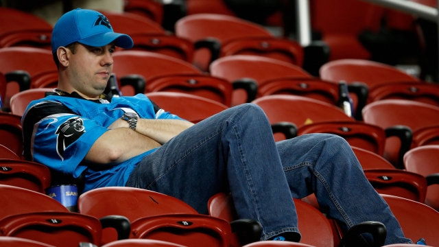 A Panthers fan stays in his seat after the end of Super Bowl 50