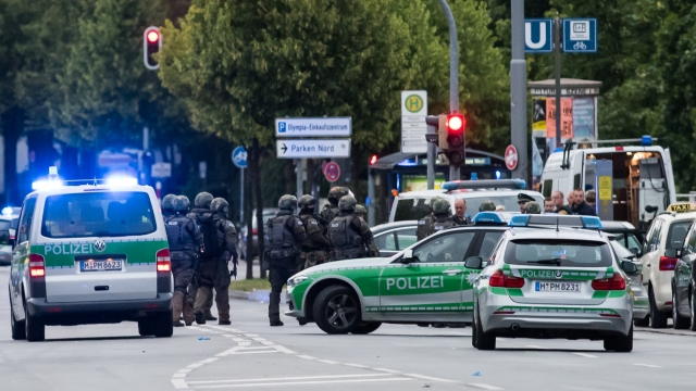 German police vehicles and officers in gear are in a street during a shooting investigation
