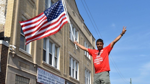 Nasir Bin Zakaria, one of nearly 1,000 Rohingya refugees resettled in Chicago in the past few years, holds the US flag.