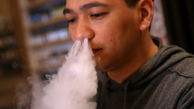 A man blows vapor from an e-cigarette.