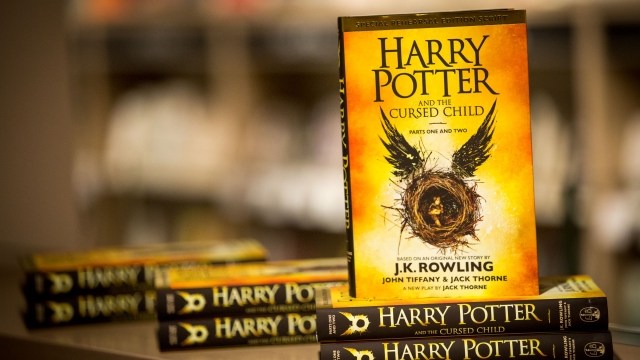 A copy of "Harry Potter and the Cursed Child" sits on a shelf.