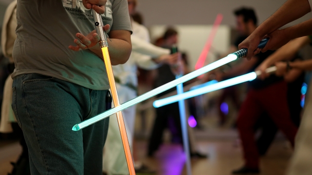 Students perform combat moves using lightsabers during a Golden Gate Knights class.