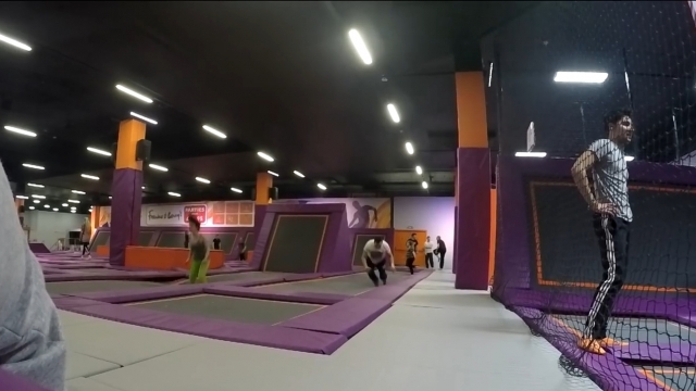 People jumping around at a trampoline park.