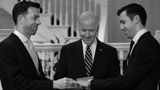 Vice President Joe Biden stands between the happy couple. All three men are wearing suits with ties.