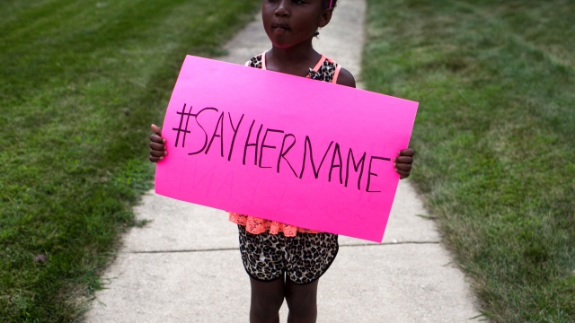 A young girl holds a sign at the funeral service for Sandra Bland.