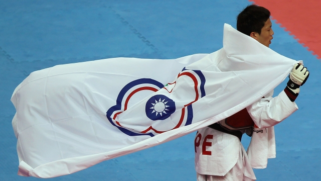 Chinese Taipei flag being held by taekwondo fighter.