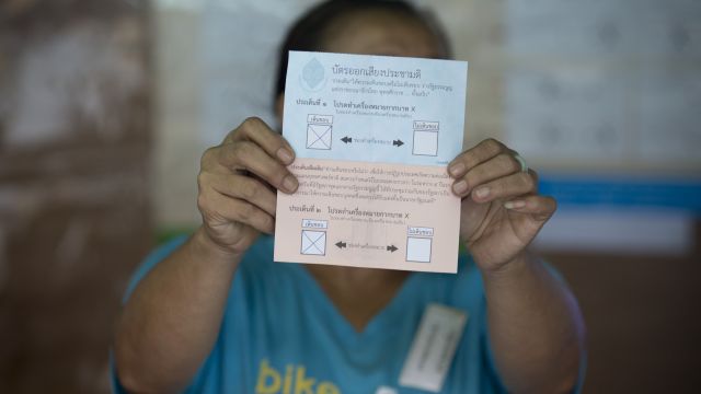 A volunteer holds a voter ballot at a polling station in Thailand.