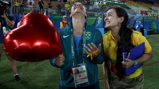 Volunteer Marjorie Enya (R) and rugby player Isadora Cerullo of Brazil smile after Enya's marriage proposal.