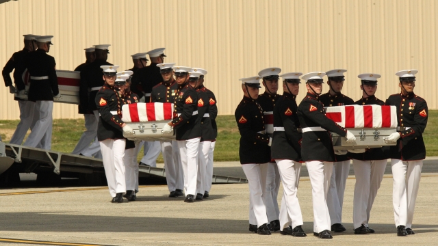 Transfer cases are carried into a hangar during the Transfer of Remains Ceremony for four Americans killed in Libya.