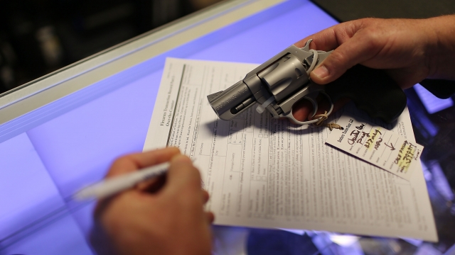 A man fills out the federal background check paperwork to purchase a gun.