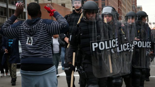 A protester holds up his hands as police in riot gear pass through during a march in honor of Freddie Gray on April 25, 2015