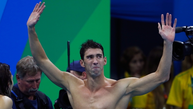 Michael Phelps waves to the crowd after his final Olympic race.