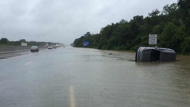 A photo from the Louisiana State Police shows floodwaters covering a road.