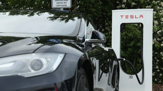 A Tesla electric-powered sedan stands at a Tesla charging staiton at a highway reststop on June 11, 2015 in Germany.