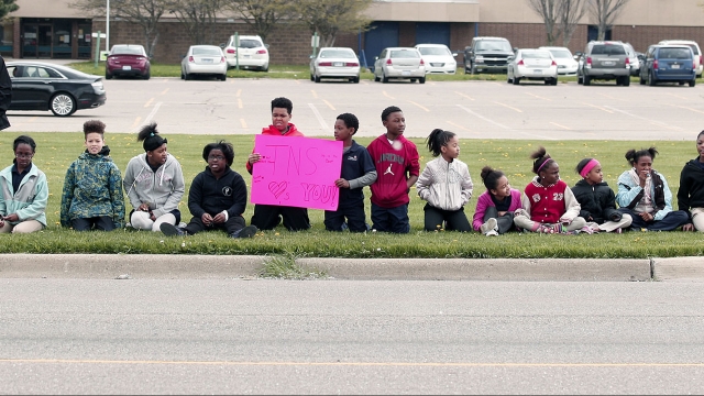 Kids sit in the grass in Flint, Michigan, in 2016.