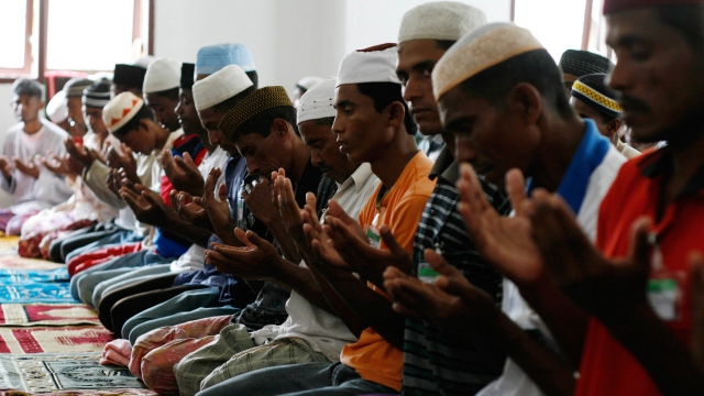 Muslim men pray at a refugee camp of Rohingya boat people.