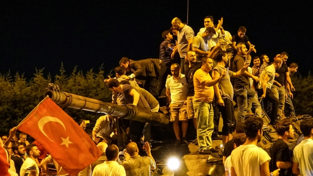 People gather on top of a Turkish armys tanks at Ataturk Airport
